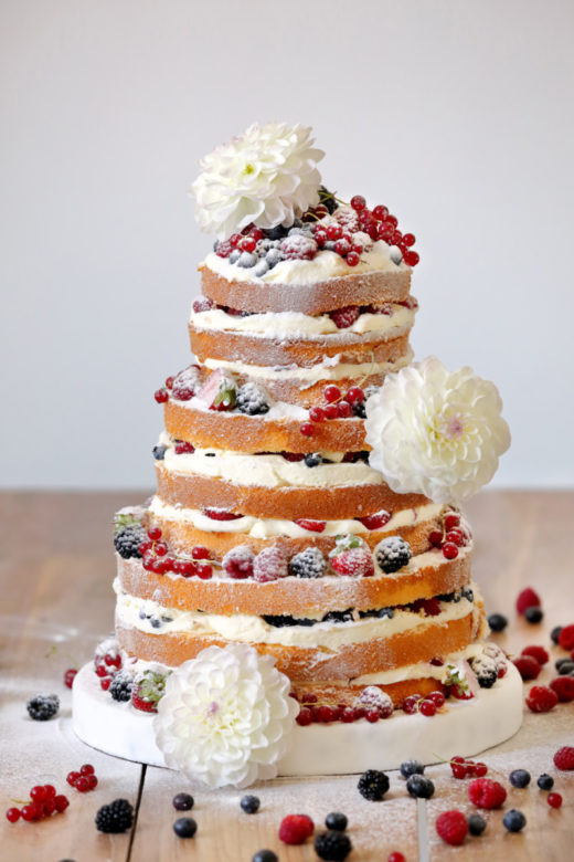 Wedding rustic naked cake with flowers on wooden background