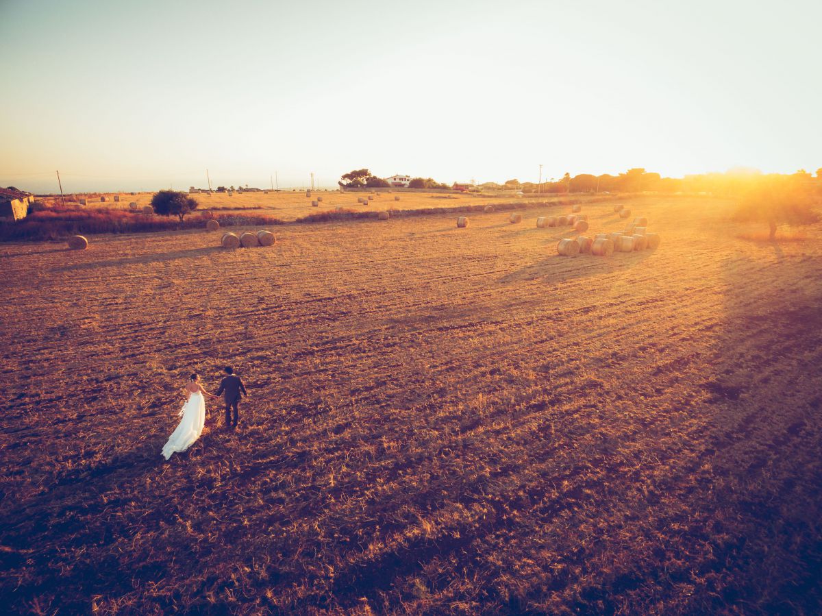 Una coppia, lei italiana lui sudcoreano, fotografata da Andrea Materia con un drone in un campo di fieno a Ragusa