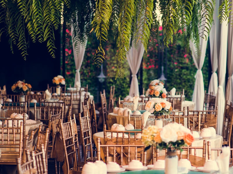 In questa foto una location per matrimonio allestita con tavoli rotondi e decorazioni aeree vegetali