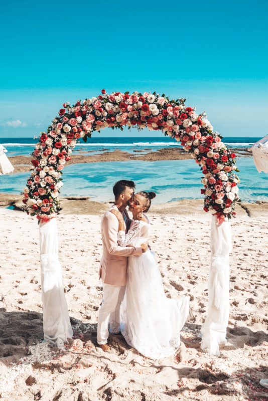 Nella foto due sposi abbracciati mentre celebrano il loro matrimonio sulla spiaggia