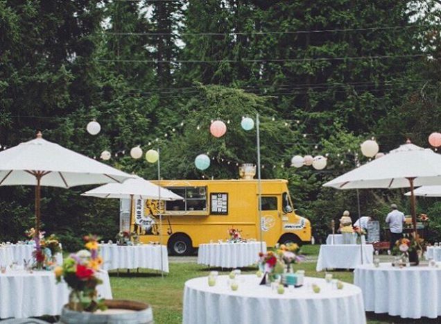 In questa foto un allestimento nuziale all'aperto, con tavoli rotondi per gli ospiti e un food truck giallo per servire il cibo