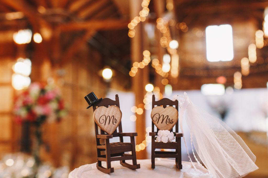 In questa foto un cake topper con due piccole sedie a dondole in legno, perfetto per un ricevimento in agriturismo matrimoni palermo
