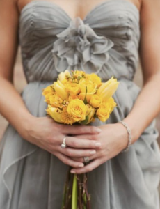 In questa foto un bouquet di fiori gialli per la damigella vestita di grigio