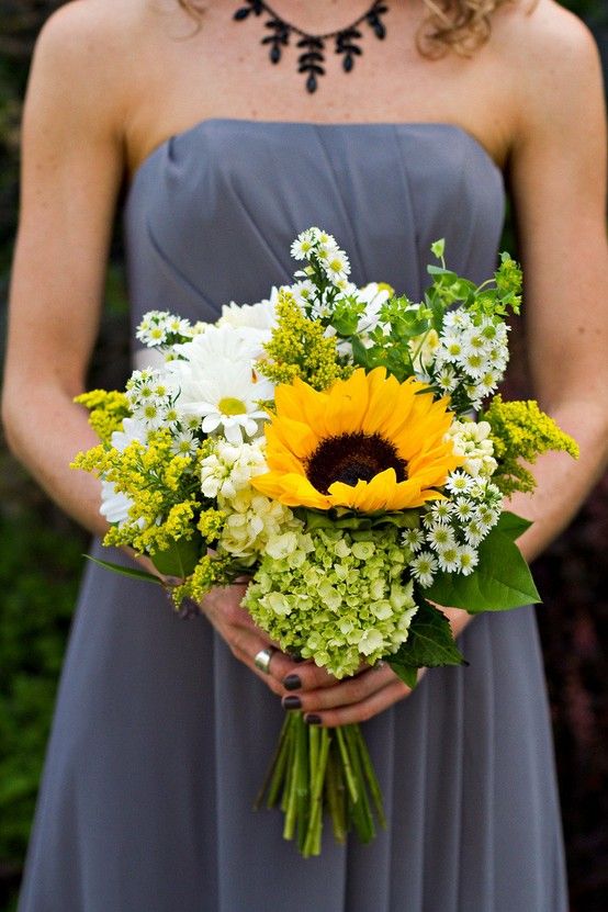 In questa foto un bouquet di girasoli, fiori bianchi e verdi