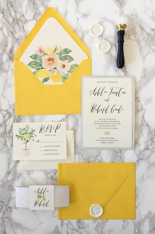 In questa foto una partecipazione di nozze nel colore matrimonio 2021: busta gialla e card in bianco e grigio