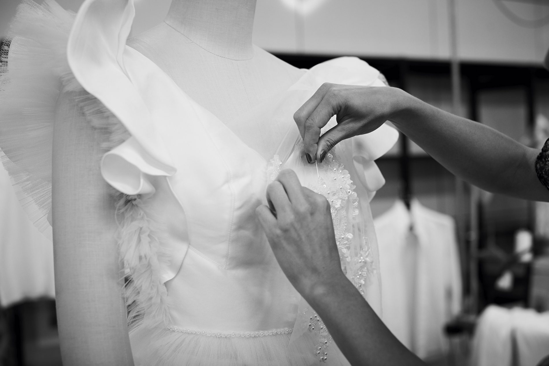 In questa foto le mani di una sarta al lavoro sulla scollatura di un abito da sposa Carlo Pignatelli: sono il simbolo perfetto di #FattoinItalia