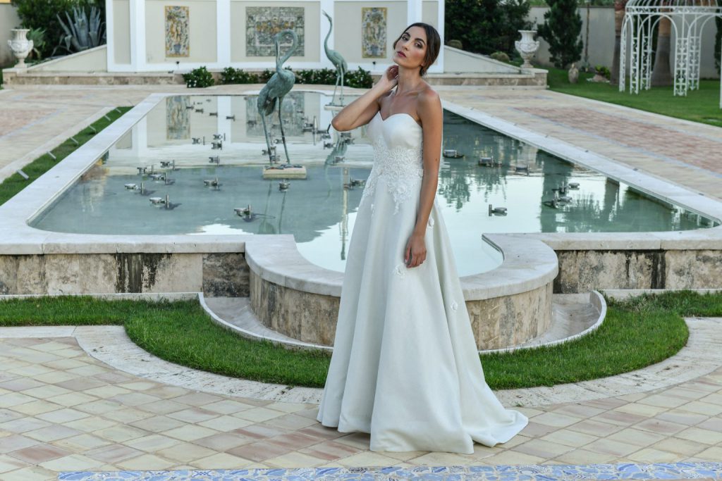 In questa foto una modella posa con un abito della collezione sposa Benedetta Laboratorio Moda 2021