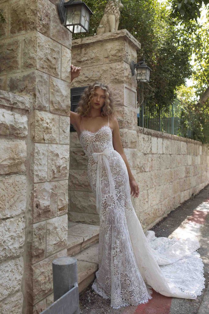 In questa foto una modella con un abito da sposa in pizzo e linea a sirena della collezione Berta 2021