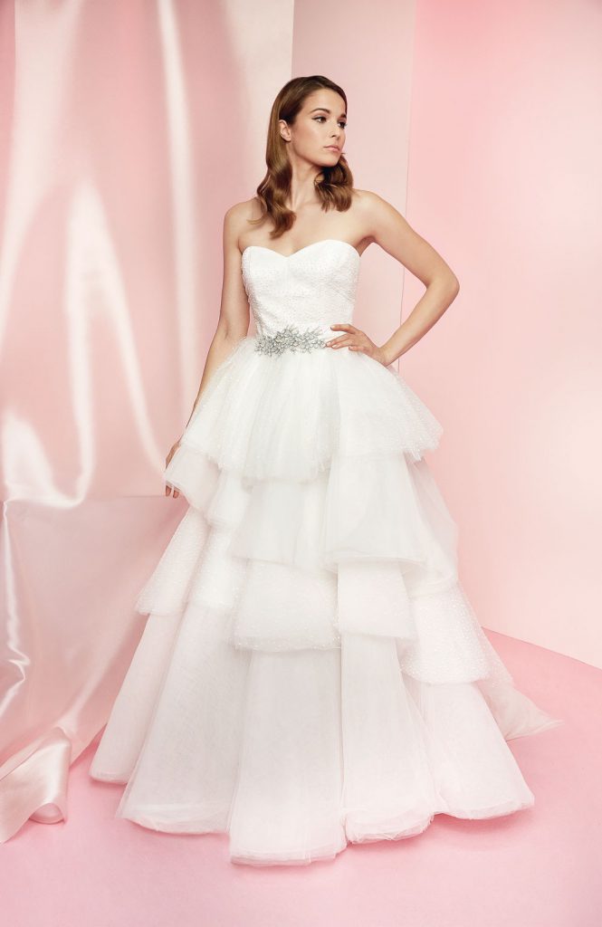 In questa foto una modella indossa un abito a balze, in tulle bianco, della collezione sposa Carlo Pignatelli 2021