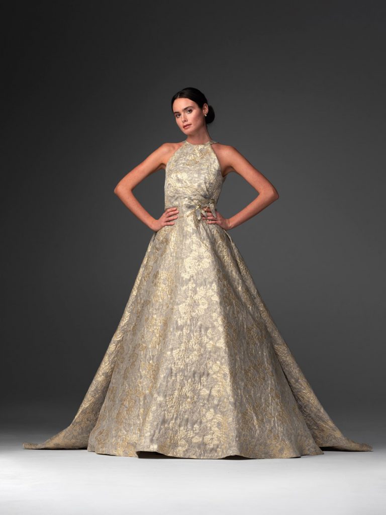 In questa foto una modella posa con un abito nei toni dell'oro della collezione sposa Chiara Vitale 2021