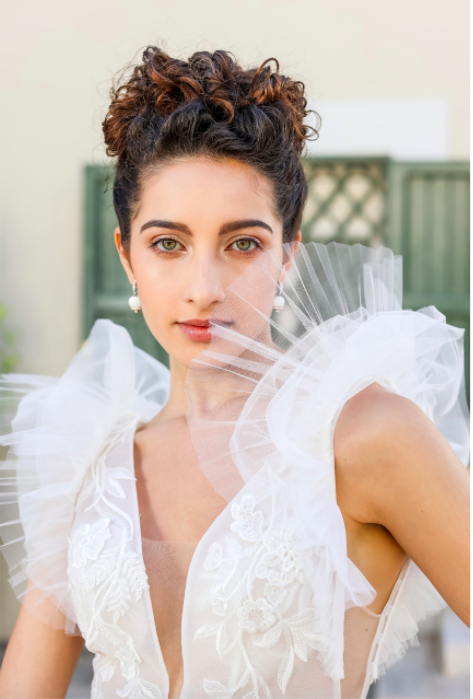 In questa foto una modella in primo piano con un abito da sposa Enzo Miccio 2021