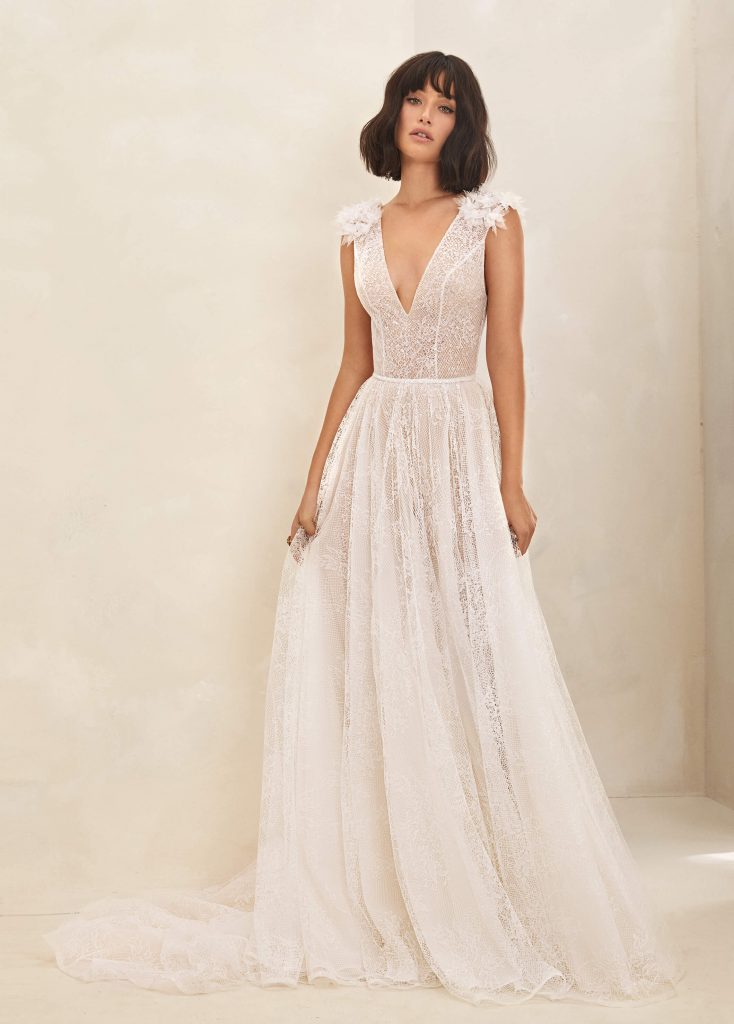 In questa foto una modella con un abito da sposa Flora Bridal 2021 con profondo scollo a V
