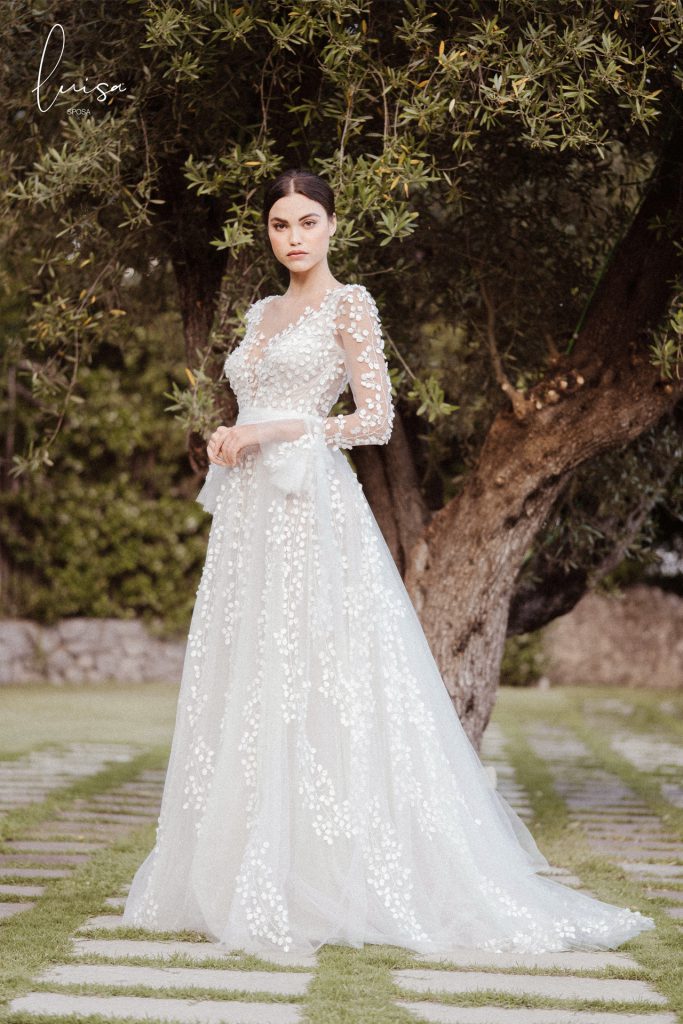 In questa foto una modella posa con un abito da sposa Luisa Sposa 2021