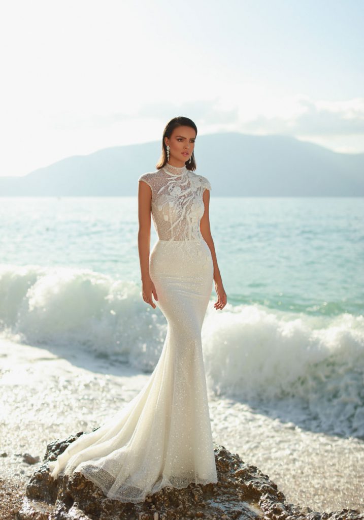 In questa foto una modella in riva al mare indossa un abito della collezione Excellence di Maison Signore 2021