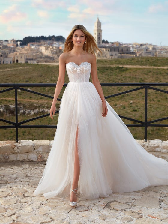 In questa foto una modella indossa un abito da sposa Nicole Milano 2021