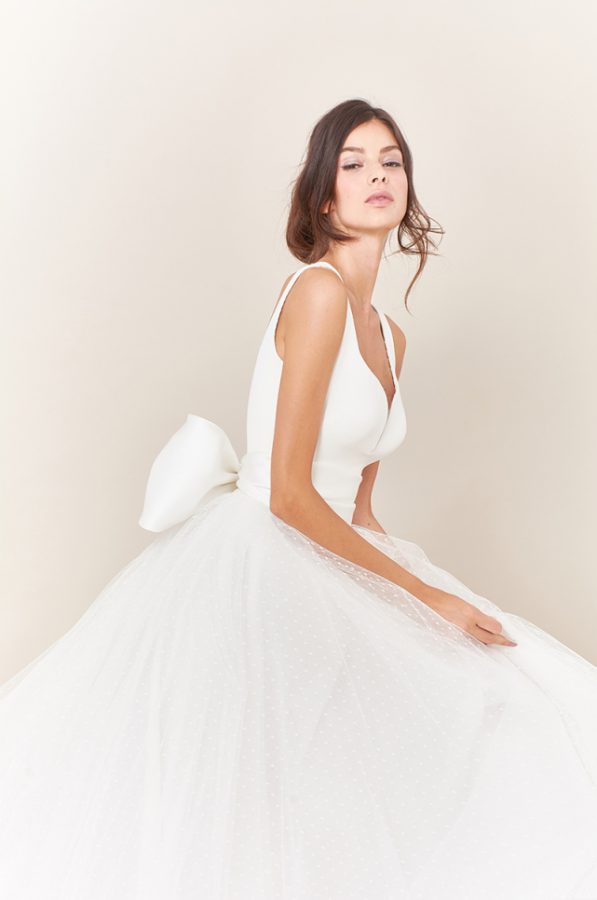 In questa foto una modella con un abito con fiocco sulla schiena della collezione Tosca Spose 2021
