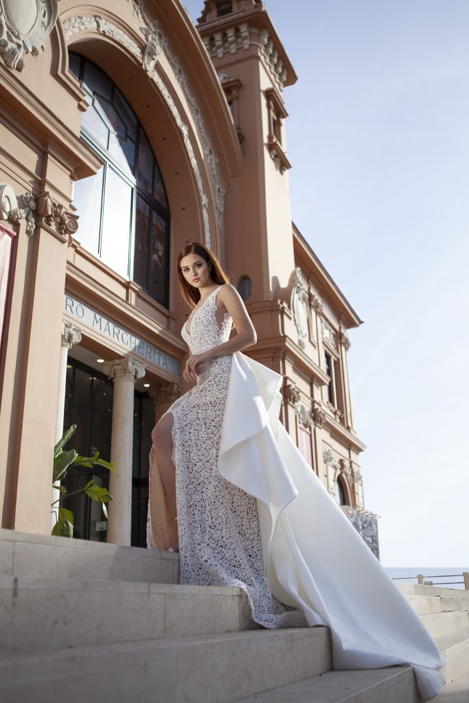In questa foto una modella con un abito da sposa con strascico della collezione Valentini Spose 2021
