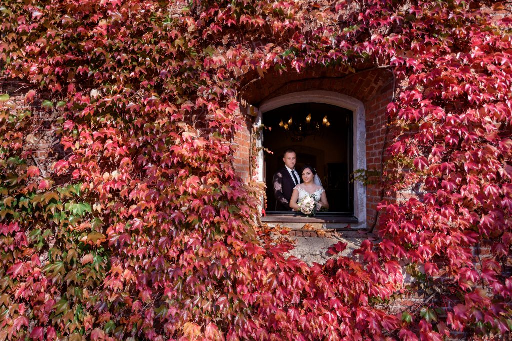 In questa foto una coppia affacciata alla finestra di un castello per matrimoni