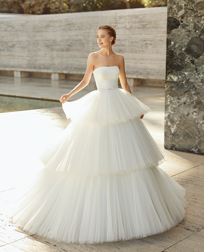 In questa foto una modella indossa un abito a balze in tulle della collezione sposa Rosa Clarà 2021