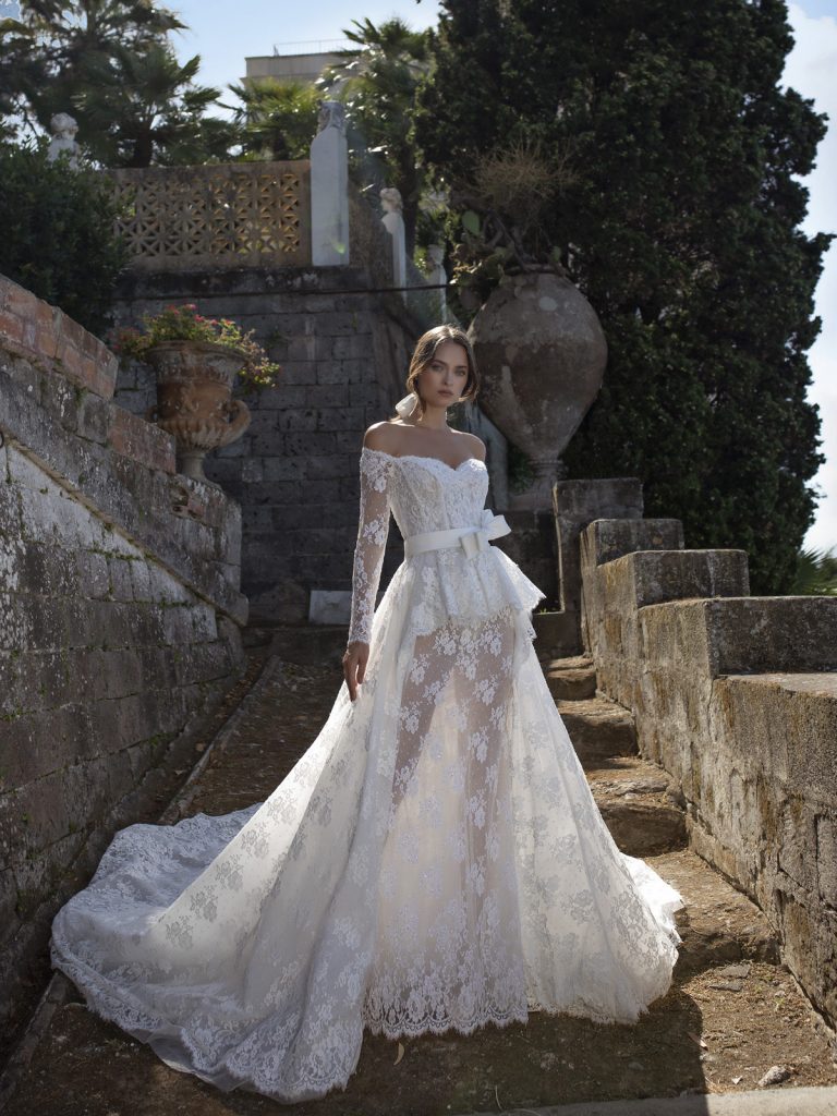 In questa foto una modella indossa un abito da sposa con maniche lunghe in pizzo