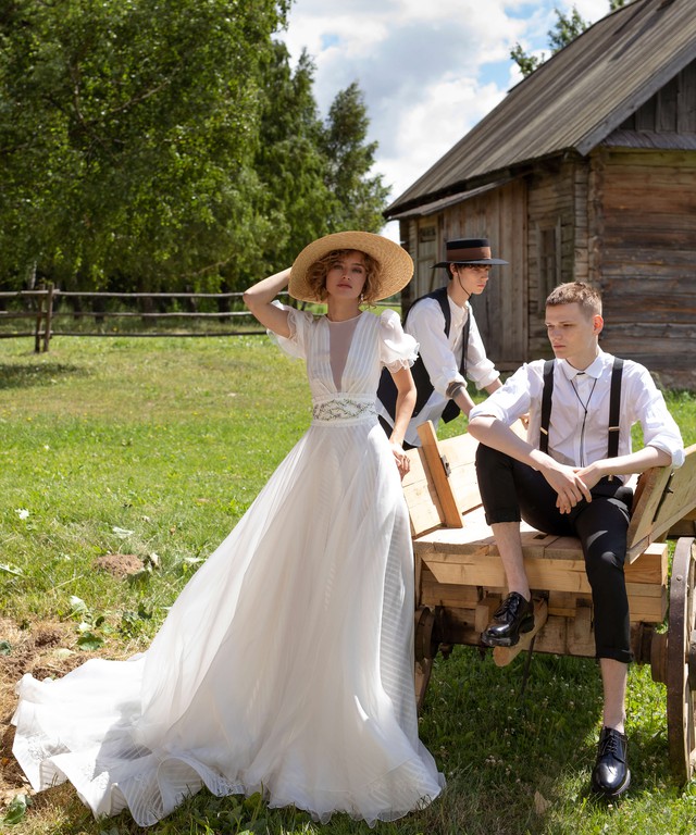 In questa foto una modella indossa un abito da sposa con maniche a palloncino e dalla linea scivolata perfetto per un matrimonio in giardino