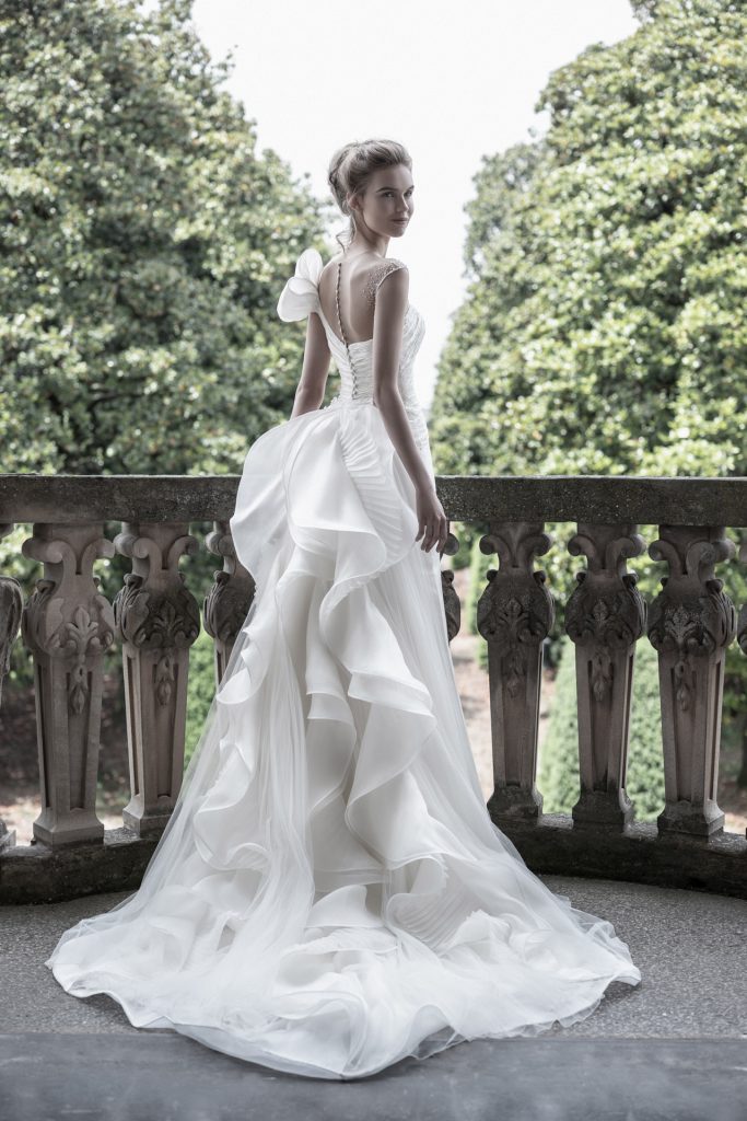 In questa foto una modella indossa un abito da sposa strutturato di Enzo Miccio Bridal perfetto per un matrimonio in un palazzo storico