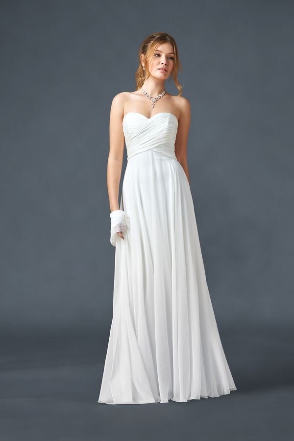 In questa foto una modella indossa un abito da sposa stile impero in chiffon con scollatura a cuore della linea Atelier Emé