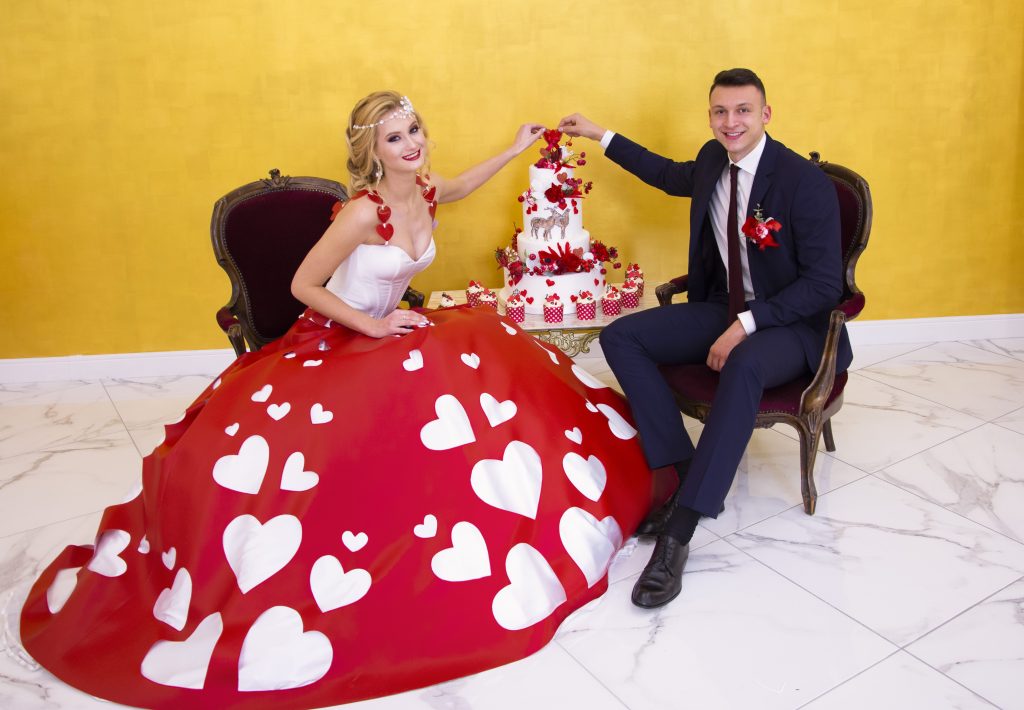 In questa foto gli sposi di Adele Vasilache con la wedding cake a tema San Valentino