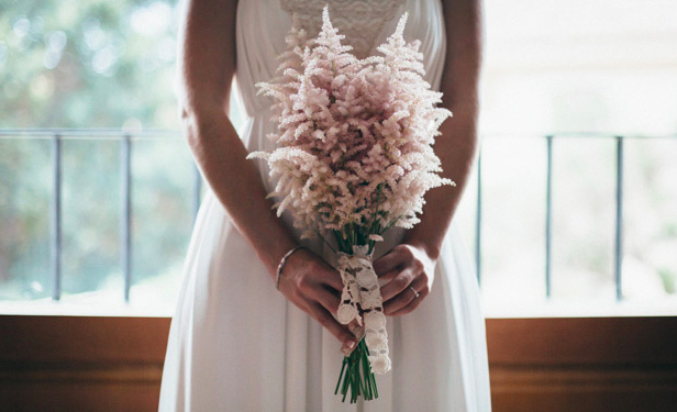 In questa foto una sposa tiene in mano il suo mazzo di astilbe, la novità in fatto di bouquet sposa 2021