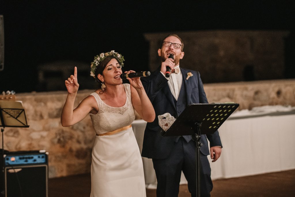 In questa foto due sposi che cantano durante il loro matrimonio