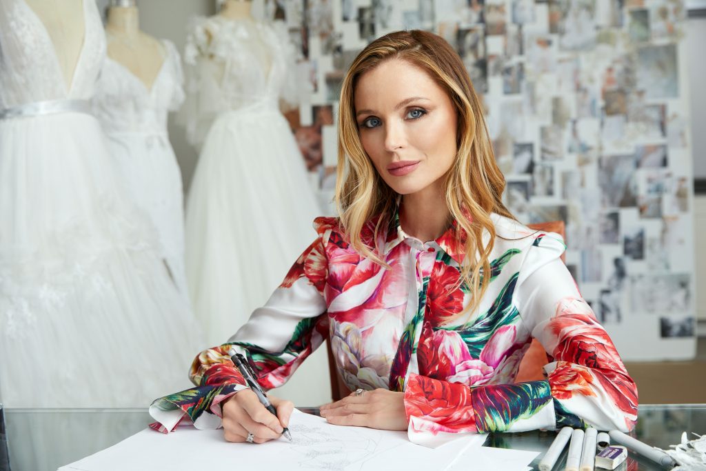 In questa foto la designer britannica e co-fondatrice di Marchesa, Georgina Chapman, seduta alla sua scrivania