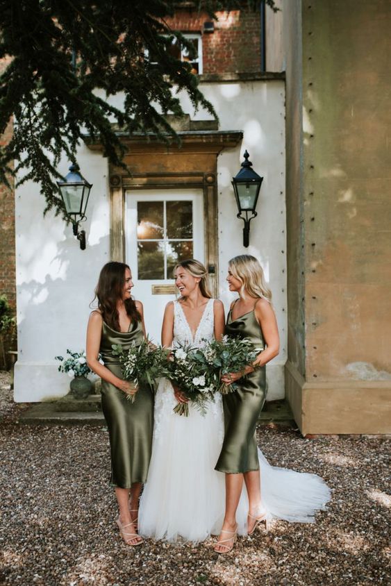 In questa foto una sposa con le sue damigelle vestite con abiti sottoveste, in raso di seta colore verde