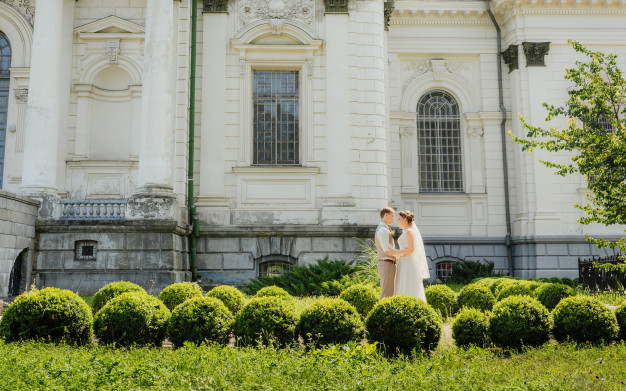 in questa foto una coppia di sposi di fronte ad un castello, location del loro matrimonio