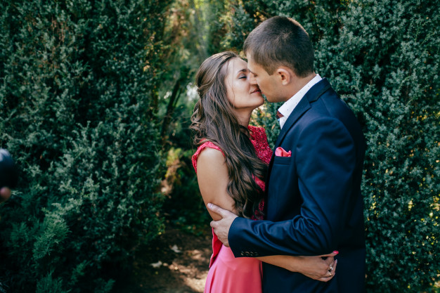 In questa foto una coppia di innamorati che si bacia in un giardino