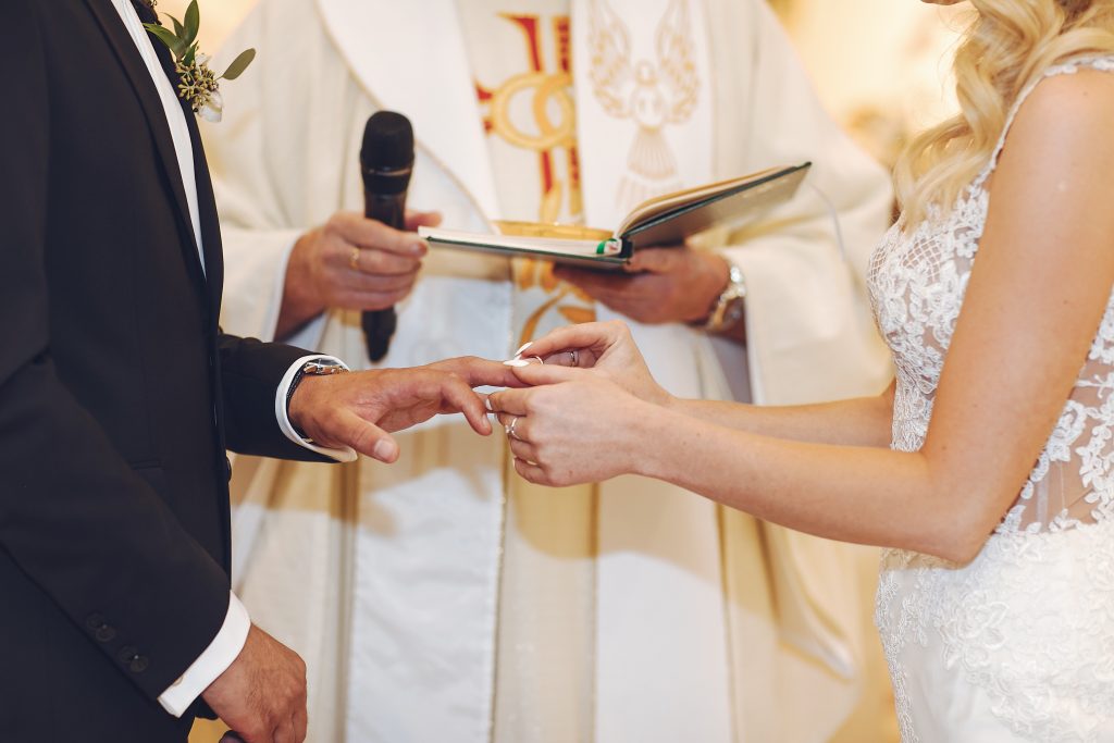 In questa foto le mani degli sposi durante lo scambio delle fedi in un matrimonio cattolico in chiesa