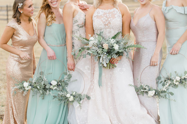 In questa foto una sposa con le sue damigelle che tengono tra le mani i loro hoop bouquet