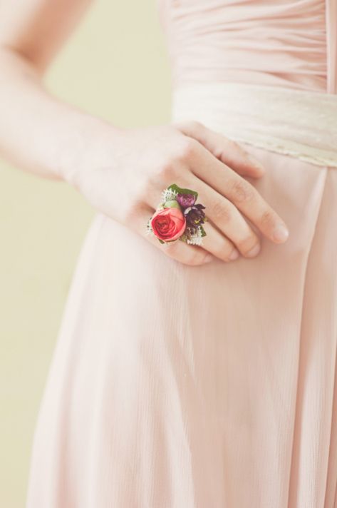 In questa foto una damigella ha al suo anulare destro un anello fatto con piccoli boccioli di fiori