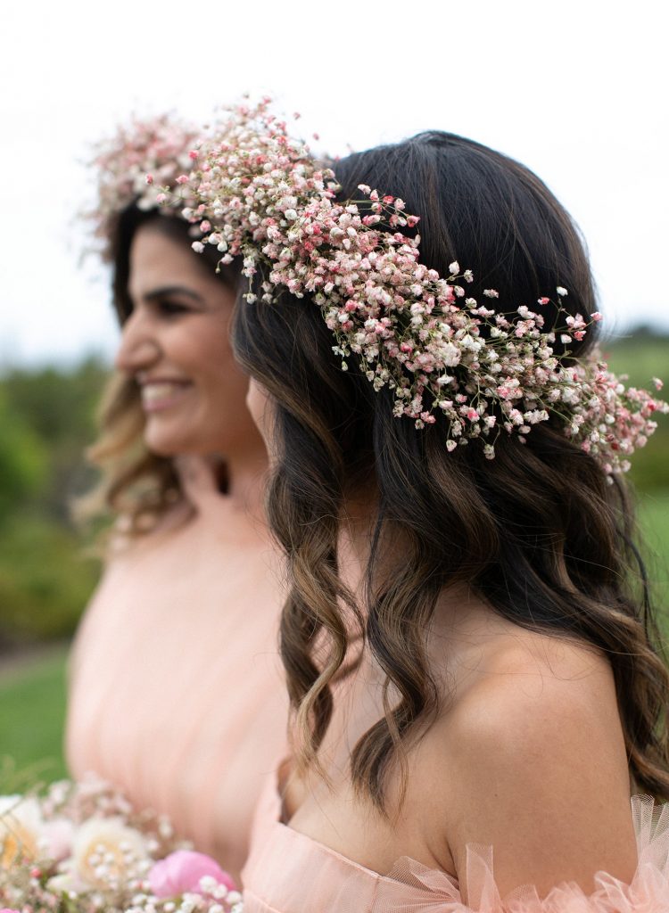 In questa foto due damigelle indossano coroncine di fiori sul capo, nei toni del rosa