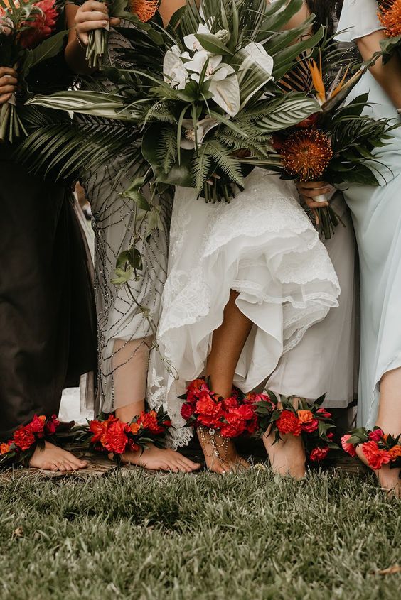 In questa foto sposa e damigelle indossano cavigliere floreali e tengono i loro bouquet tra le mani