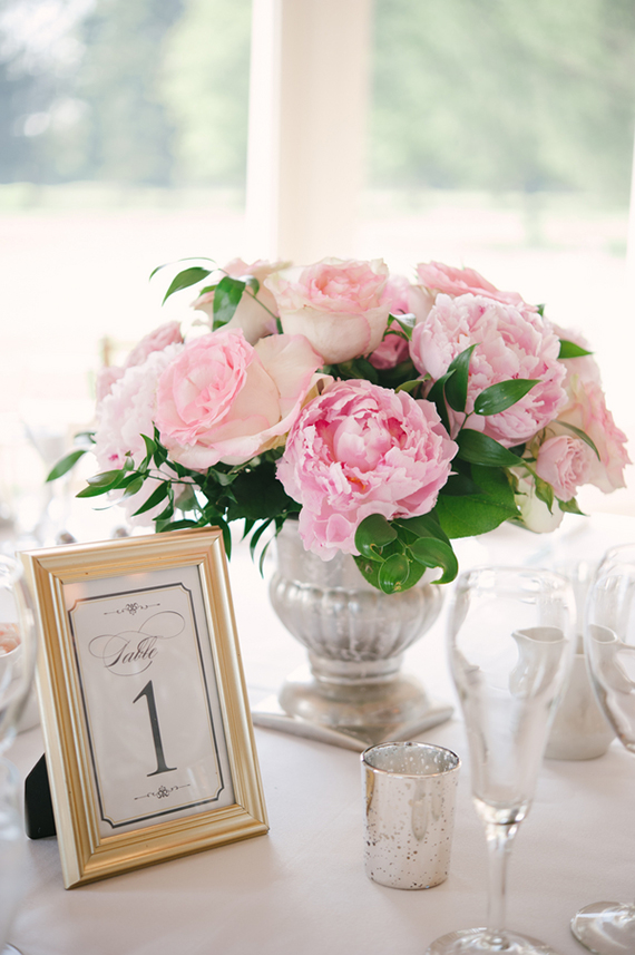 In questa foto un centrotavola matrimonio con peonie rosa in un vaso dorato 