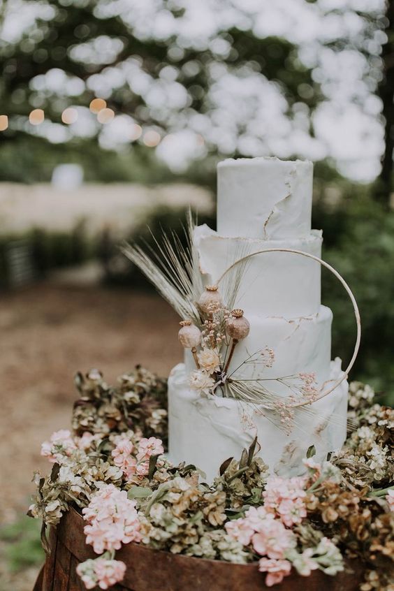 In questa foto una torta nuziale decorata con un hula hoop e fiori 