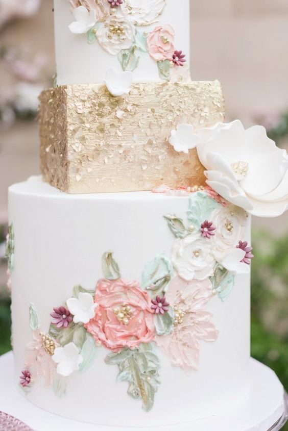 In questa foto una torta a 3 piani, di cui il centrale squadrato, decorata con motivi floreali