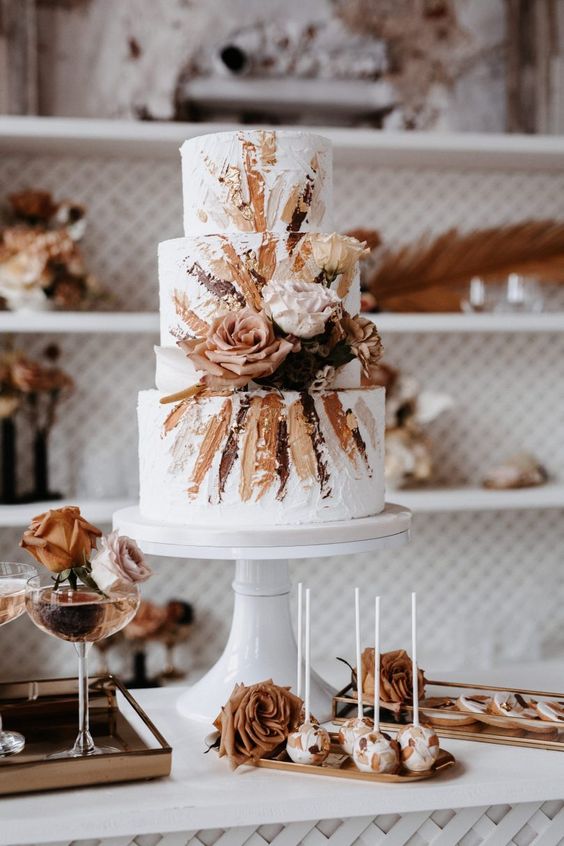 In questa foto una torta di matrimonio autunnale, decorata con un disegno nei toni del marrone chiaro e scuro