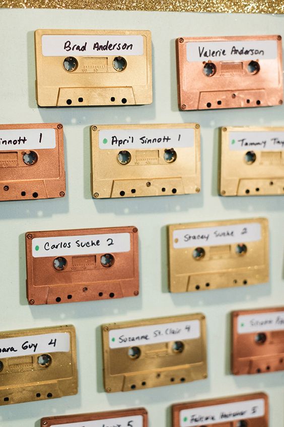 In questa foto un tableau mariage con audiocassette nei colori oro e bronzo ideale per un matrimonio vintage a tema anni 80