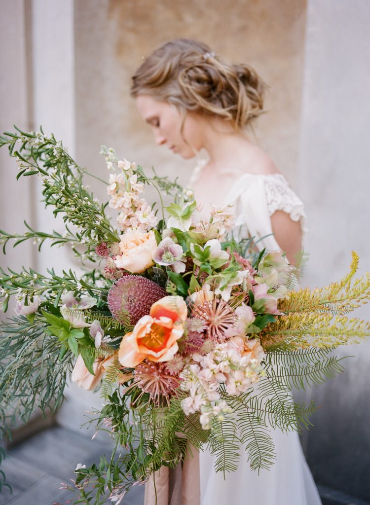 In questa foto un bouquet a bvraccio con fiori di campo, peonie, succulente e ramoscelli di ulivi e palmette