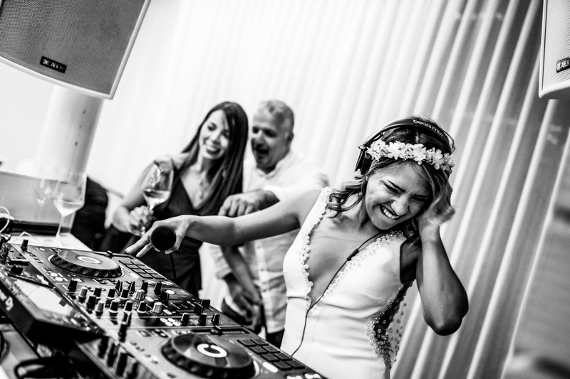 In questa foto una sposa alla console del dj mentre passa musica per il suo matrimonio