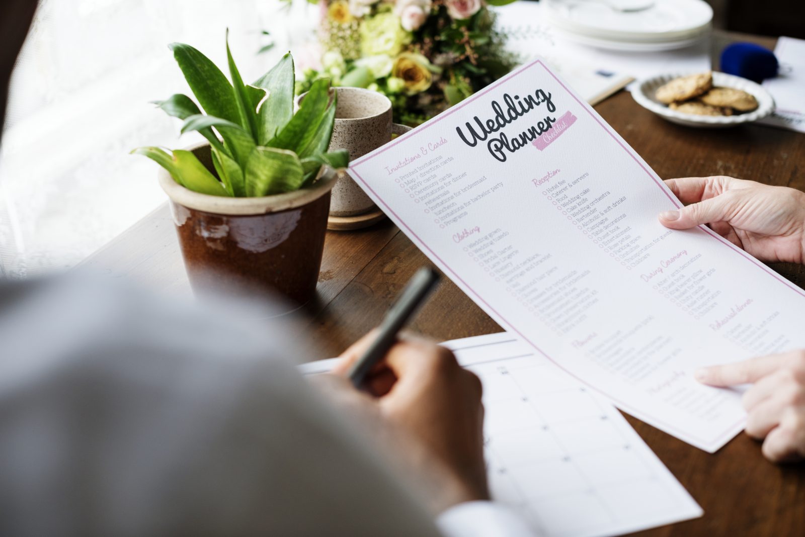 In questa foto un wedding planner tiene in mano una scheda per organizzare un matrimonio
