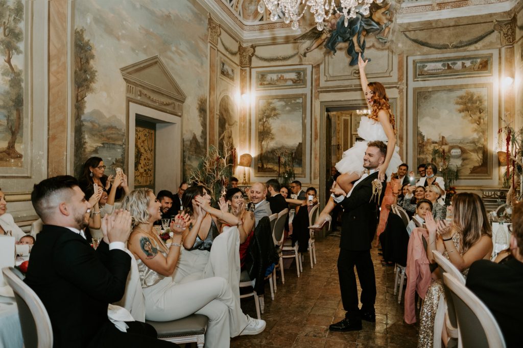 In questa foto di Martina Botti la sposa è in braccio al marito durante il ricevimento