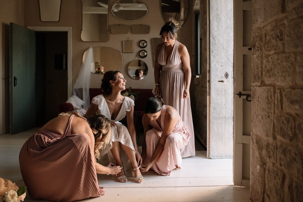 In questa foto di Primopiano Photografica di Rosa Lipari la sposa si sta vestendo insieme alle amiche