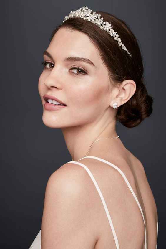 In questa foto una modella indossa un diadema da sposa con perline e piccoli fiorellini di cristalli